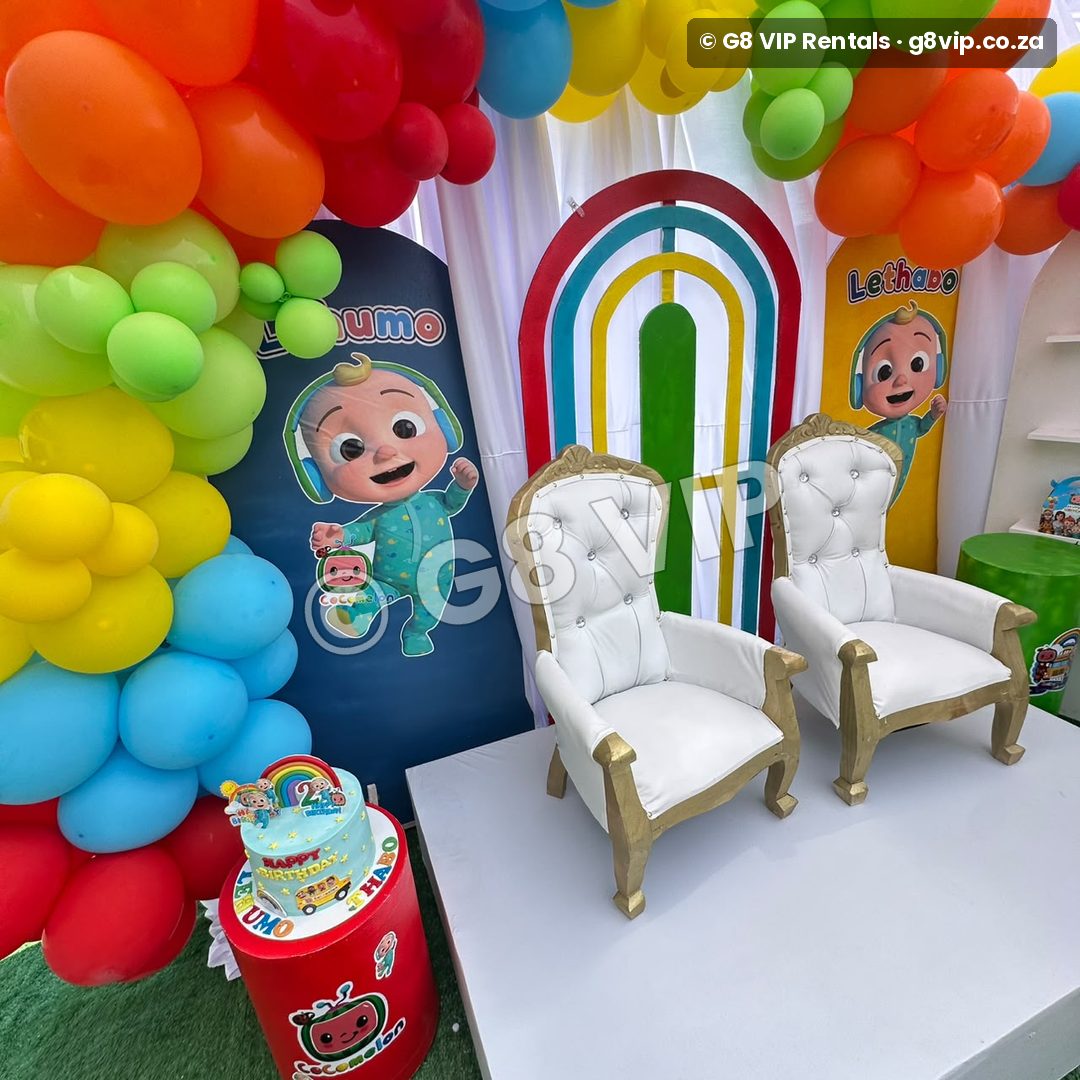 Platinum party by G8 VIP: rainbow backdrop with white throne chairs and cake table